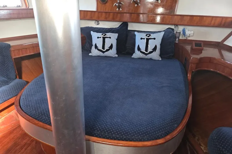 Cookie Monster Too Yacht Photos Pics Cozy cabin interior of 1982 Tayana Center Cockpit Cutter Ketch with nautical-themed pillows.