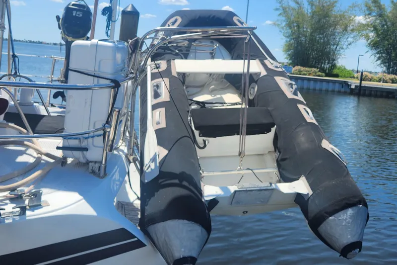 Cookie Monster Too Yacht Photos Pics 1982 Tayana Center Cockpit Cutter Ketch with inflatable dinghy on deck, docked by the water.