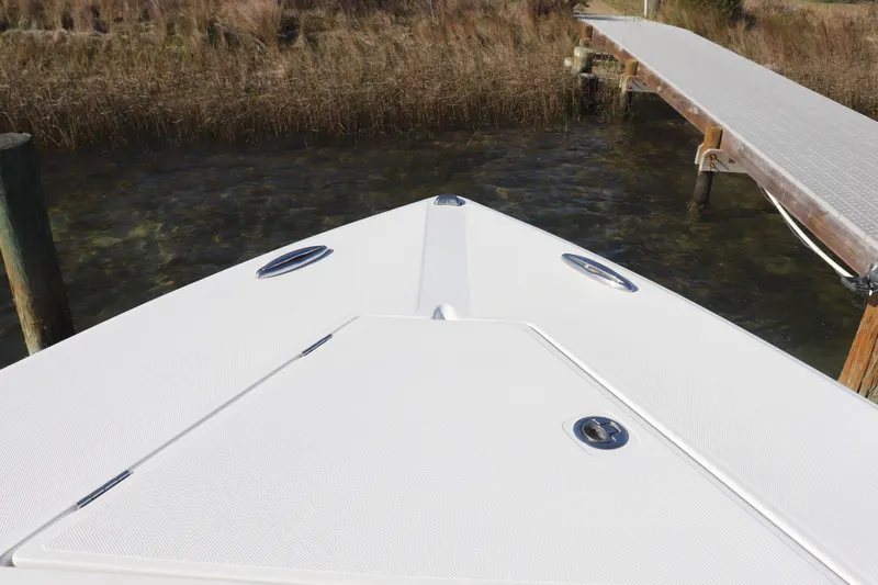  Yacht Photos Pics Bow of a 2013 Jupiter 30 boat docked near a wooden pier.