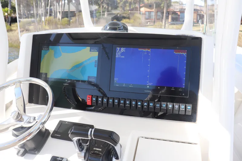  Yacht Photos Pics Control panel of a 2013 Jupiter 30 boat with navigation screens and steering wheel.