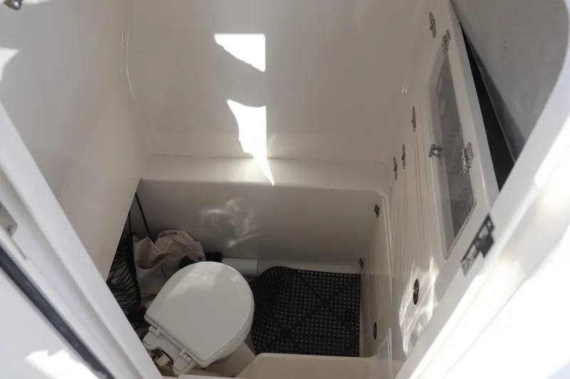  Yacht Photos Pics Compact marine bathroom in 2013 Jupiter 30 boat, featuring a toilet and storage area.