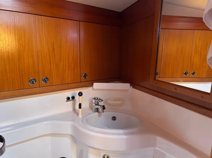 Kells Yacht Photos Pics Bathroom interior of 1996 Nautor Swan 44 Mk II yacht with wooden cabinets and sink.