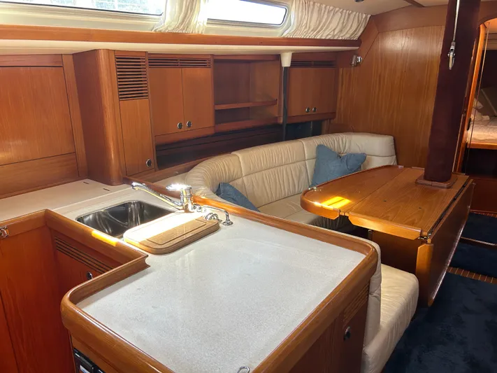 Kells Yacht Photos Pics Interior of 1996 Nautor Swan 44 Mk II yacht with wooden cabinetry and cozy seating area.
