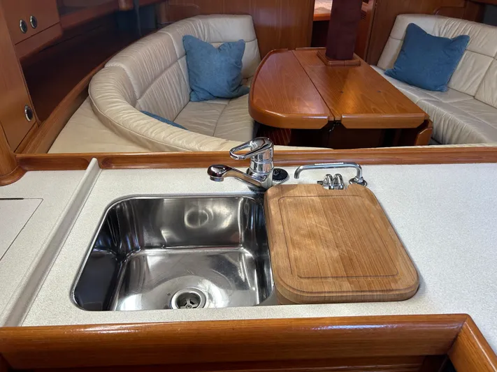 Kells Yacht Photos Pics Interior of 1996 Nautor Swan 44 Mk II yacht with sink and wooden dining area.