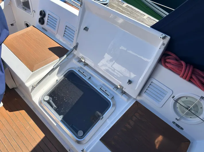 Kells Yacht Photos Pics Open hatch on 1996 Nautor Swan 44 Mk II sailboat deck, with wooden seating and red rope.