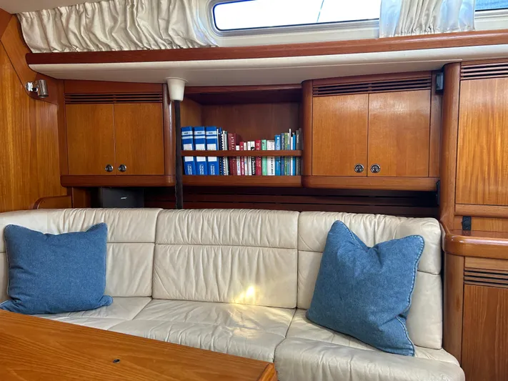 Kells Yacht Photos Pics Interior of 1996 Nautor Swan 44 Mk II yacht with bookshelves and cushioned seating.