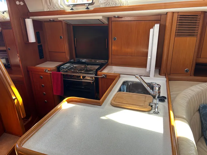 Kells Yacht Photos Pics Interior of 1996 Nautor Swan 44 Mk II yacht kitchen with stove, sink, and wooden cabinetry.