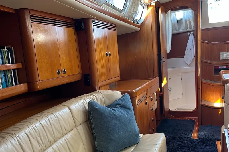 Kells Yacht Photos Pics Interior of 1996 Nautor Swan 44 Mk II yacht with wooden cabinetry and beige seating.