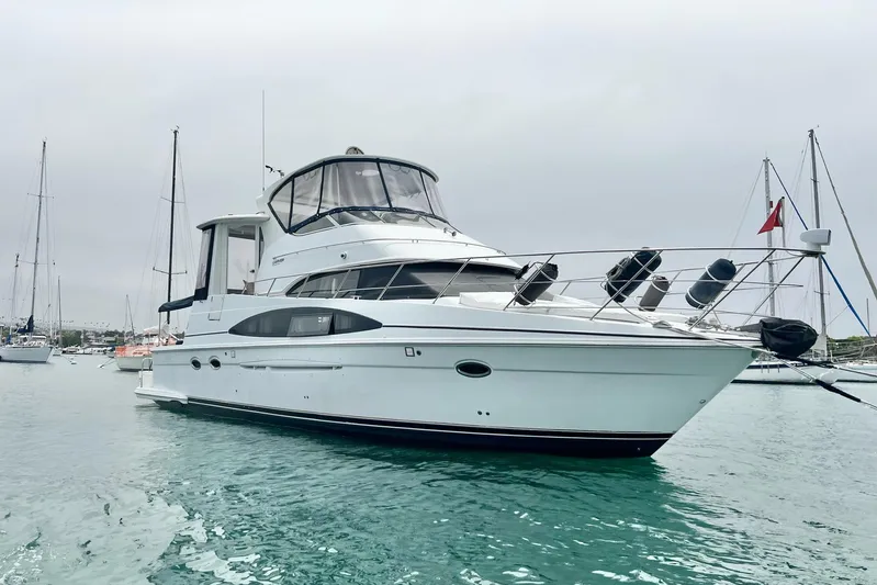  Yacht Photos Pics 2003 Carver 444 Cockpit Motor Yacht on calm water, surrounded by sailboats.