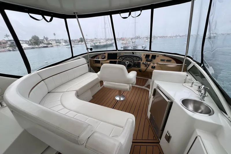  Yacht Photos Pics 2003 Carver 444 Cockpit Motor Yacht interior with white seating and helm, overlooking marina.