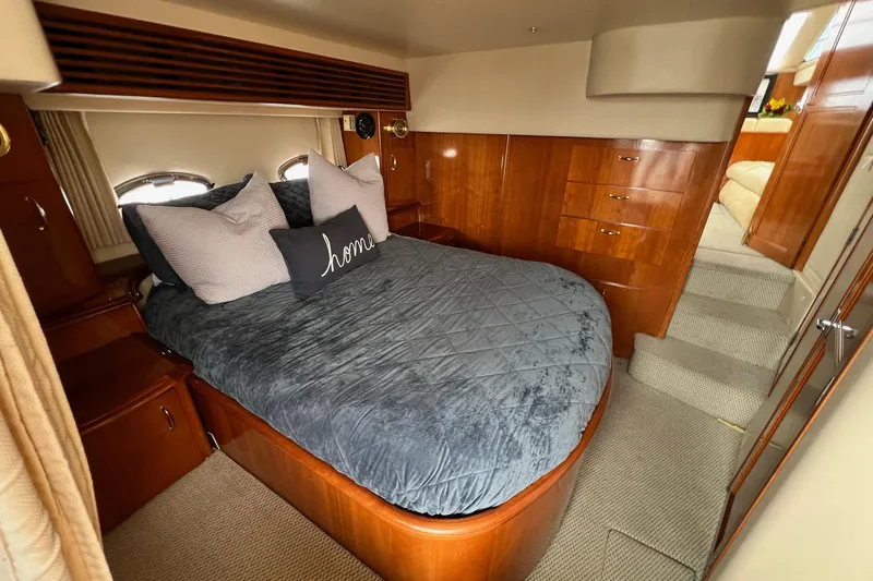  Yacht Photos Pics Luxurious bedroom interior of 2003 Carver 444 Cockpit Motor Yacht with plush bedding and wood cabinetry.
