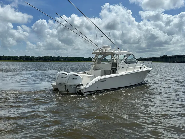  Yacht Photos Pics 2023 Pursuit OS 325 Offshore boat on water under cloudy sky.