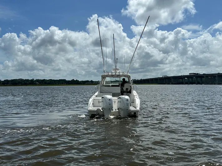  Yacht Photos Pics 2023 Pursuit OS 325 Offshore boat on water under cloudy sky.
