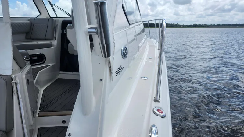  Yacht Photos Pics 2023 Pursuit OS 325 Offshore boat on water, showcasing sleek design and interior seating.