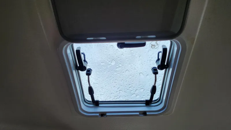  Yacht Photos Pics Open hatch with raindrops on glass, Pursuit OS 325 Offshore 2023 boat.