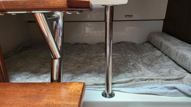  Yacht Photos Pics 2023 Pursuit OS 325 Offshore cabin interior with bed and wooden steps.