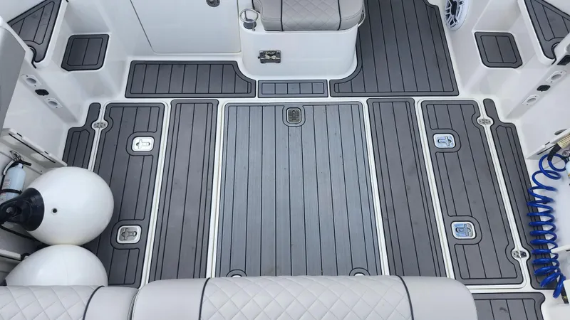  Yacht Photos Pics 2023 Pursuit OS 325 Offshore boat deck with gray non-slip flooring and storage compartments.