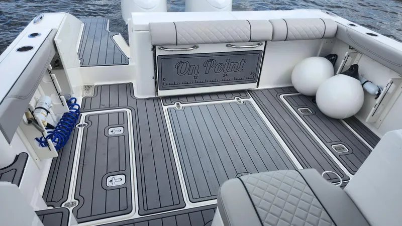  Yacht Photos Pics 2023 Pursuit OS 325 Offshore boat deck with cushioned seating and storage compartments.