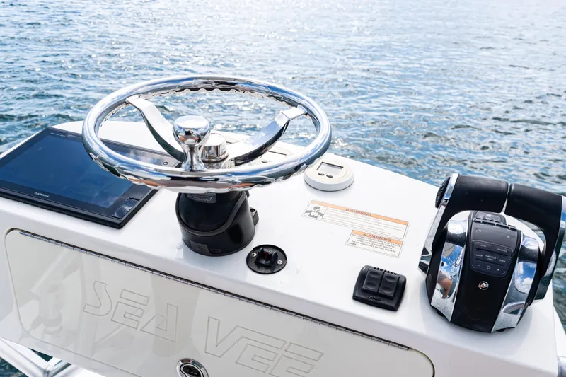  Yacht Photos Pics Control panel of a 2018 SeaVee 370Z boat with steering wheel and navigation equipment.