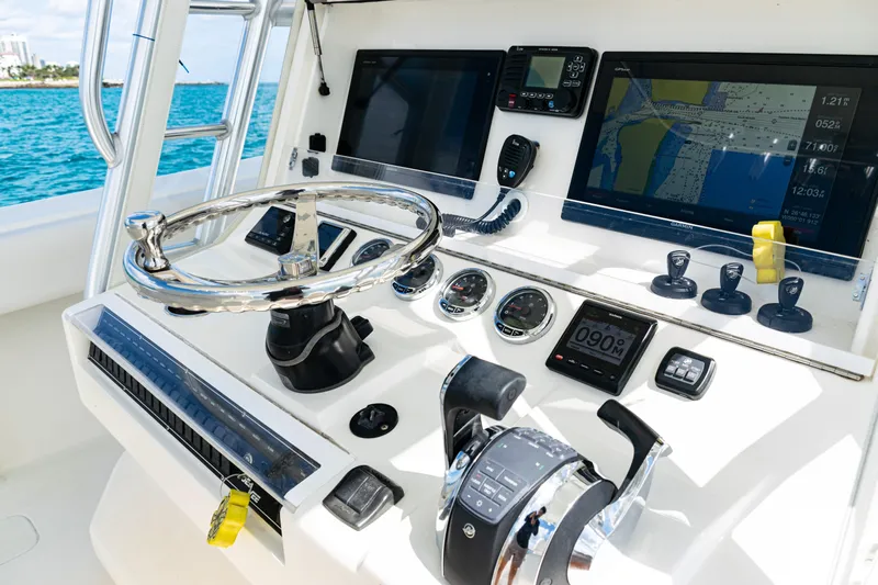  Yacht Photos Pics Control panel of a 2018 SeaVee 370Z boat with navigation screens and steering wheel.