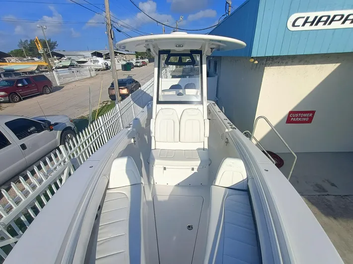 23-374 Yacht Photos Pics 2025 Regulator 23 boat with white interior, parked near a blue building and vehicles.