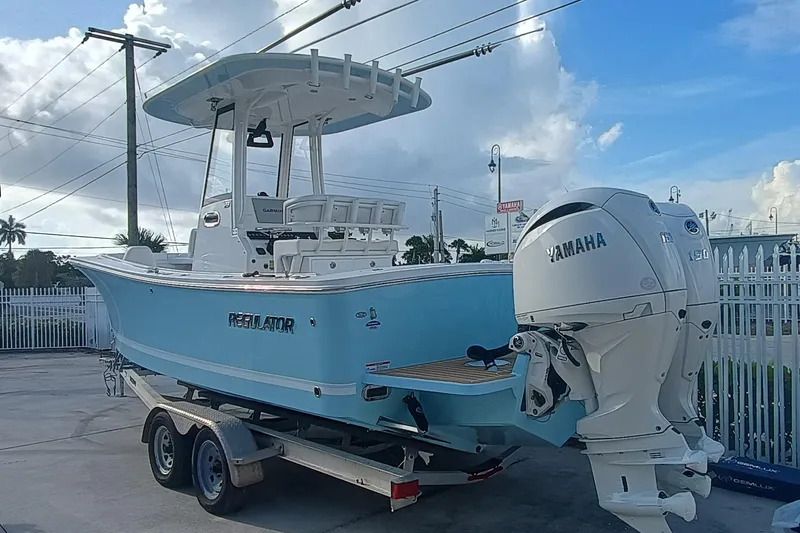 23-374 Yacht Photos Pics 2025 Regulator 23 boat with Yamaha engines on a trailer, parked outdoors.