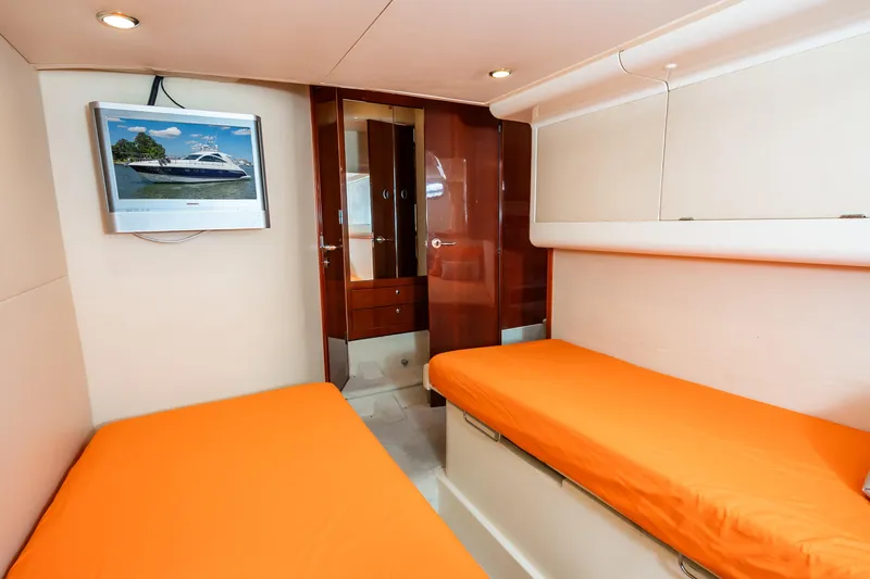 Ami Kids Donation: Meditrina Yacht Photos Pics Interior of 2006 Fairline Targa 47 GT yacht with twin beds and wall-mounted TV.