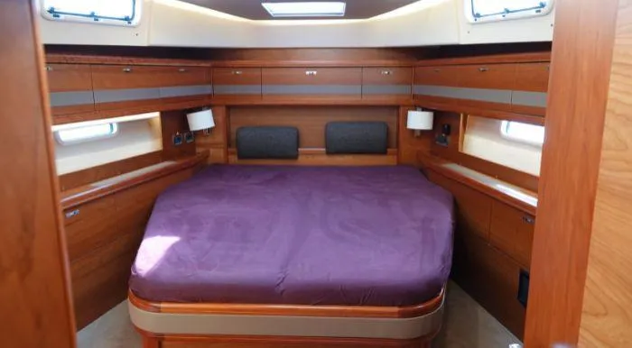 Heolia Yacht Photos Pics Luxurious cabin interior of 2018 Hanse Moody 54 DS yacht with wooden finish and large bed.