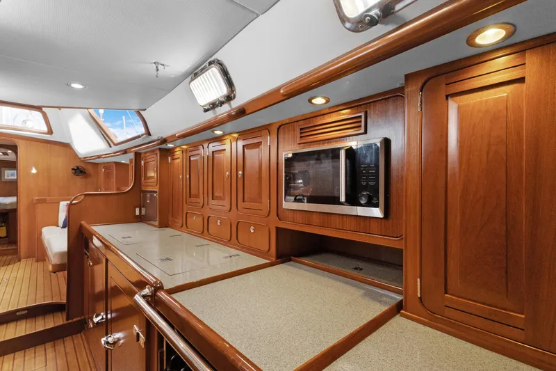 Clarity Yacht Photos Pics Luxurious 2009 Hylas 54 yacht interior with wooden cabinetry and modern kitchen amenities.