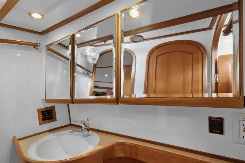 Clarity Yacht Photos Pics Luxurious bathroom interior of 2009 Hylas 54 yacht with wooden accents and mirrored cabinets.