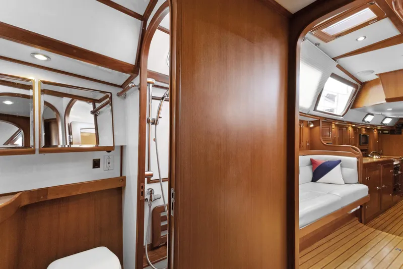 Clarity Yacht Photos Pics Luxurious 2009 Hylas 54 yacht interior with wood finish, featuring a cozy seating area and bathroom.