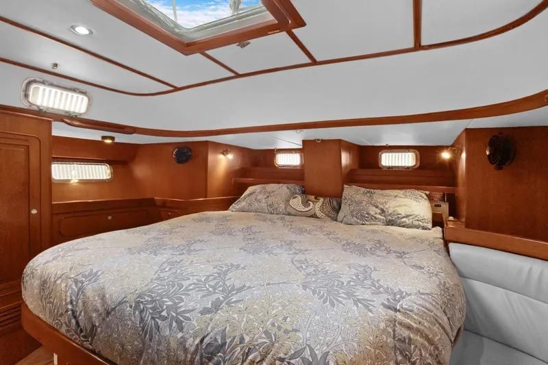 Clarity Yacht Photos Pics Luxurious cabin interior of 2009 Hylas 54 yacht with cozy bedding and wooden accents.