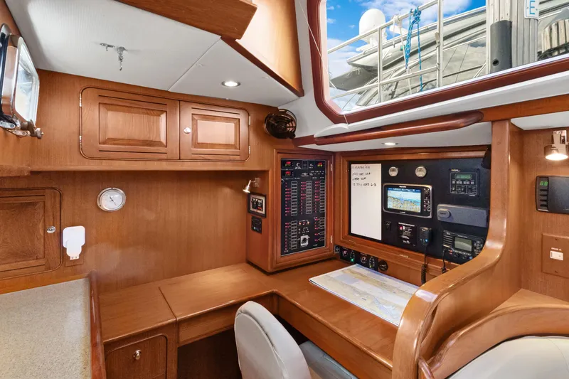 Clarity Yacht Photos Pics 2009 Hylas 54 yacht interior with navigation station and wooden cabinetry.