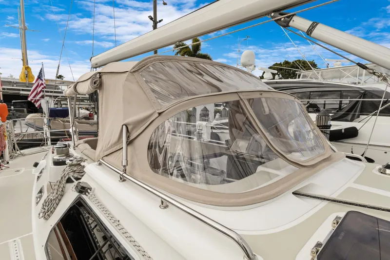 Clarity Yacht Photos Pics 2009 Hylas 54 sailboat with beige canopy docked at marina under blue sky.