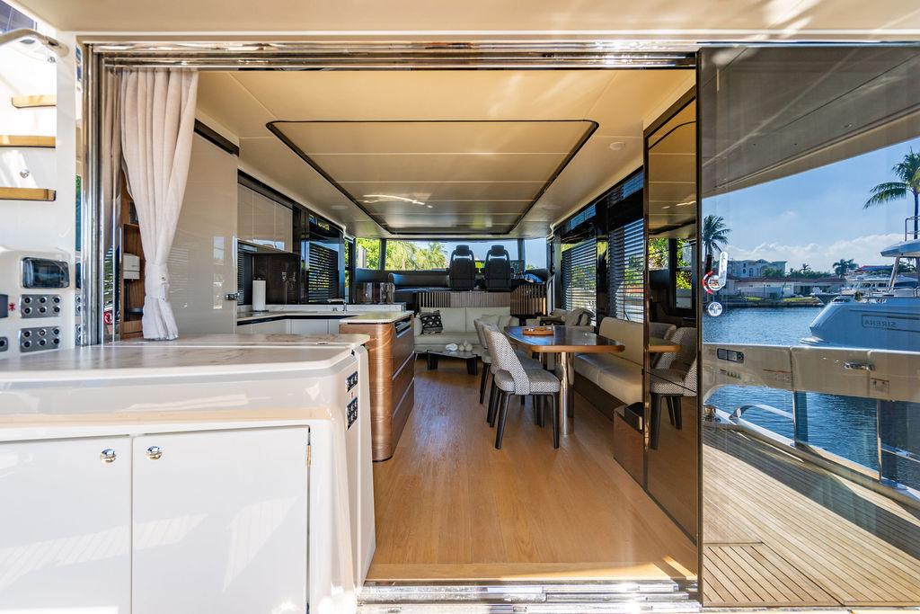 Luxurious interior of 2023 Absolute 64 Navetta yacht with modern furnishings and waterfront view.