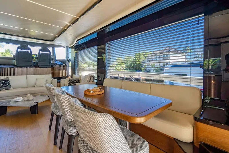 Kingship Yacht Photos Pics Luxurious interior of 2023 Absolute 64 Navetta yacht with elegant dining area and panoramic windows.
