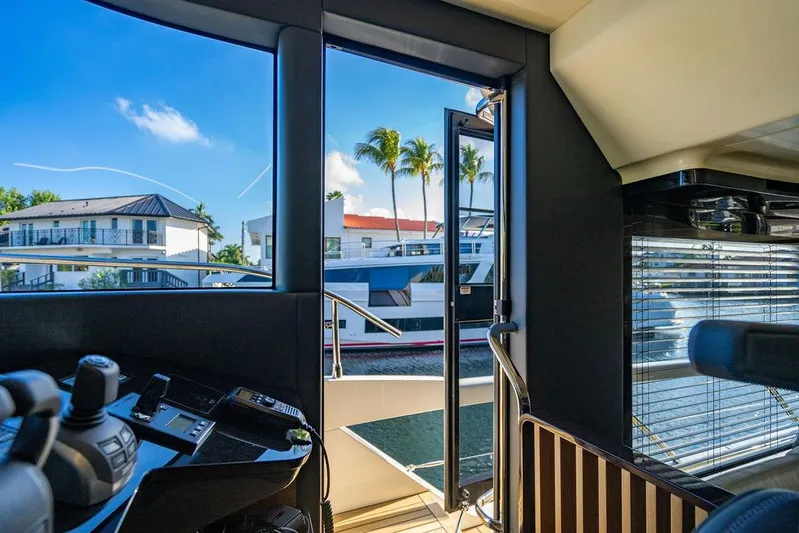 Kingship Yacht Photos Pics Interior view of 2023 Absolute 64 Navetta yacht with open door and waterfront scenery.