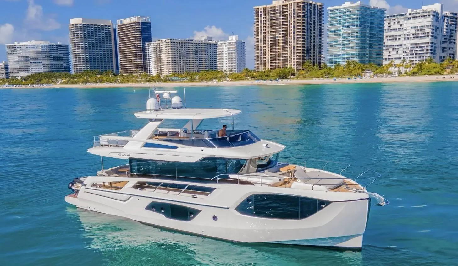 Luxury 2023 Absolute 64 Navetta yacht cruising near city skyline.