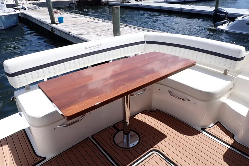  Yacht Photos Pics 2019 Carver C37 Coupe yacht with elegant wooden table and cushioned seating on deck.