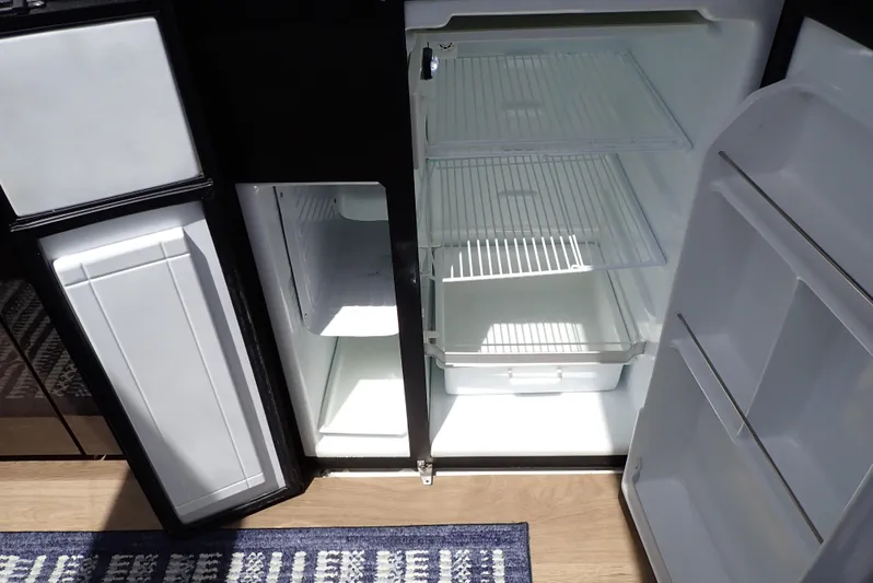  Yacht Photos Pics Refrigerator inside 2019 Carver C37 Coupe yacht, featuring open doors and empty shelves.