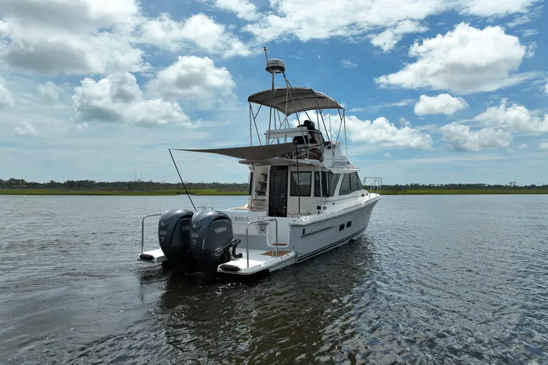 Motivated Yacht Photos Pics 2022 Cutwater C-32 CB boat cruising on a calm lake under a partly cloudy sky.