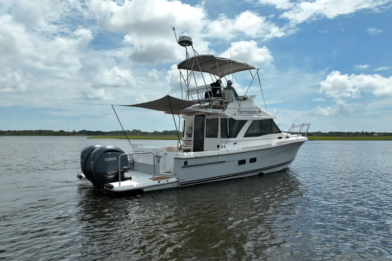Motivated Yacht Photos Pics 2022 Cutwater C-32 CB boat on calm water under a partly cloudy sky.