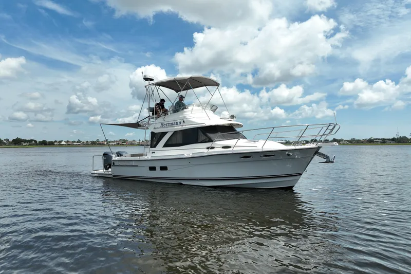 Motivated Yacht Photos Pics 2022 Cutwater C-32 CB boat cruising on a calm lake under a partly cloudy sky.