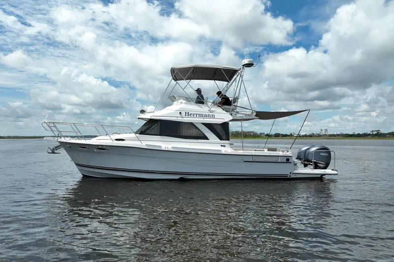 Motivated Yacht Photos Pics 2022 Cutwater C-32 CB boat cruising on a calm waterway under a partly cloudy sky.