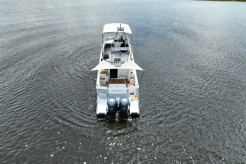 Motivated Yacht Photos Pics 2022 Cutwater C-32 CB boat on water, rear view with dual engines.