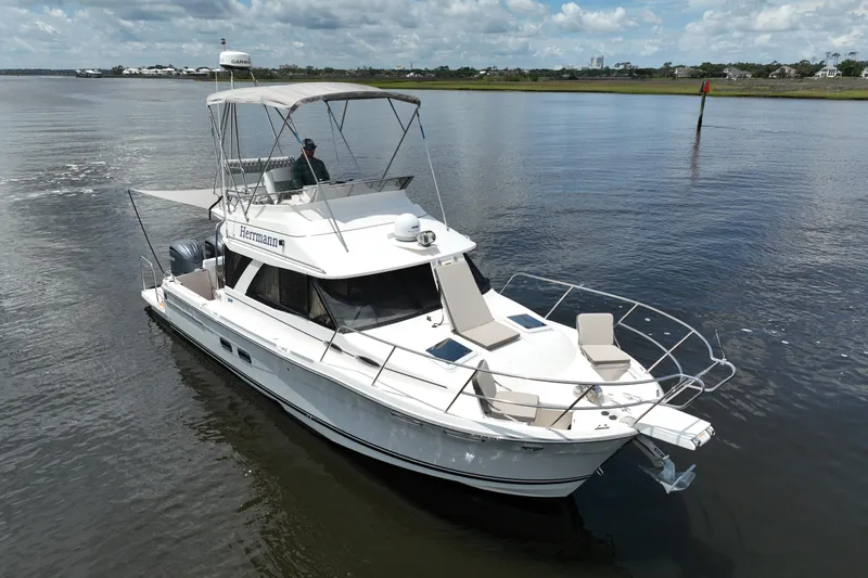 Motivated Yacht Photos Pics 2022 Cutwater C-32 CB boat cruising on a calm river under a cloudy sky.