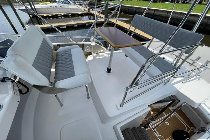 Motivated Yacht Photos Pics 2022 Cutwater C-32 CB boat seating area with table, docked at marina.