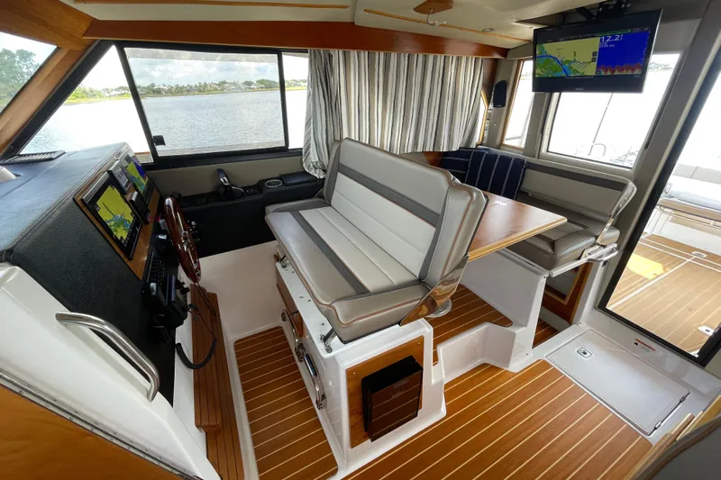 Motivated Yacht Photos Pics Interior of 2022 Cutwater C-32 CB boat with seating, navigation screens, and wood flooring.