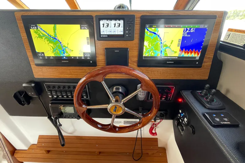 Motivated Yacht Photos Pics 2022 Cutwater C-32 CB helm with Garmin displays and wooden steering wheel.