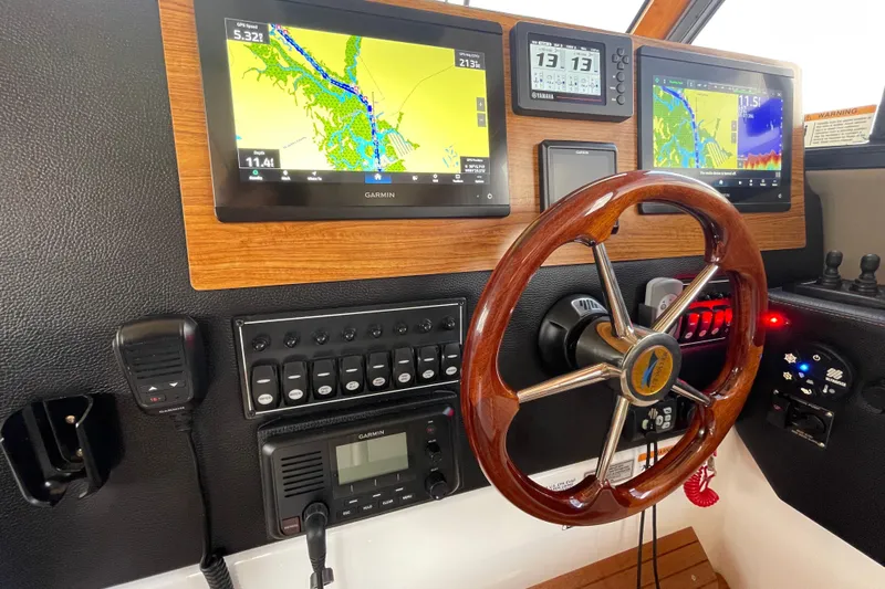 Motivated Yacht Photos Pics 2022 Cutwater C-32 CB helm with Garmin navigation displays and wooden steering wheel.
